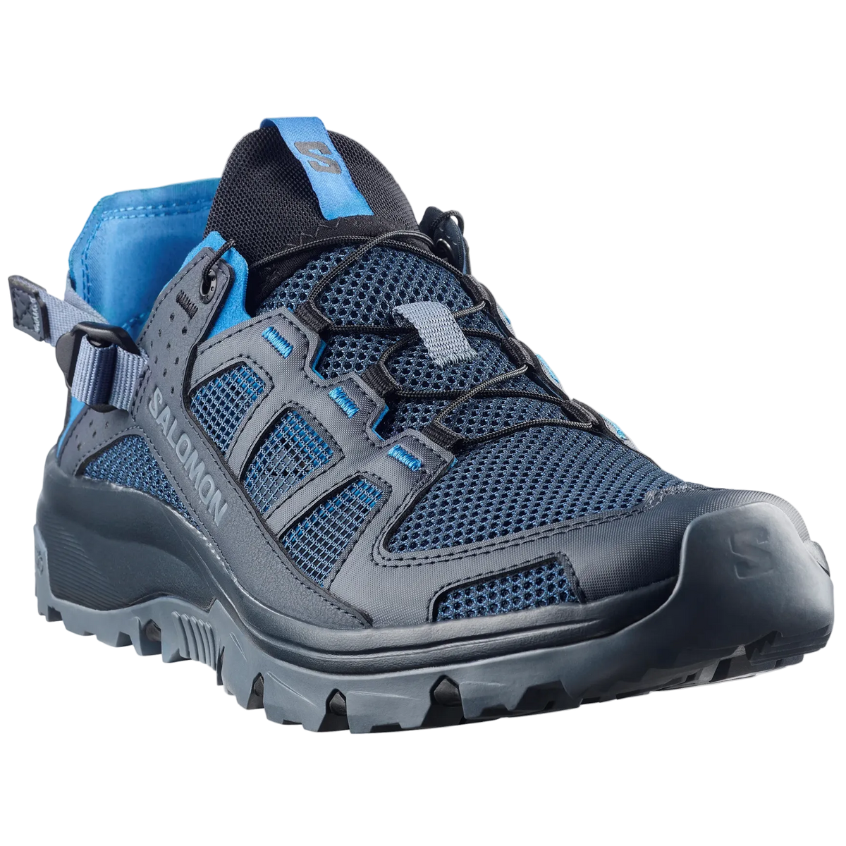 A Salomon hiking shoe in dark gray and blue mesh with a black lace-up system and a blue pull tab, shown from a three-quarters angle on a light gray background.
