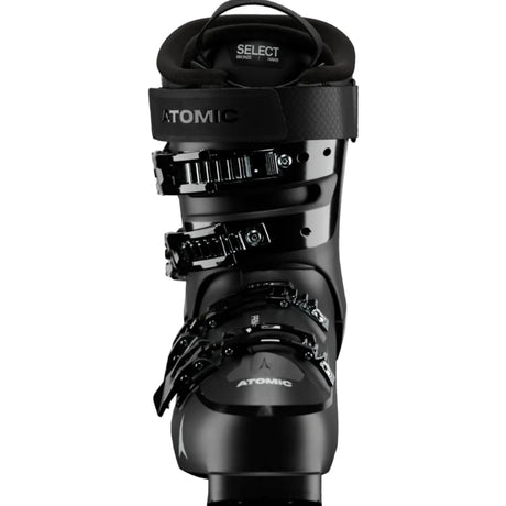 A close-up studio shot of a black Atomic Select ski boot, showing the buckle system, ankle strap, and lower shell.