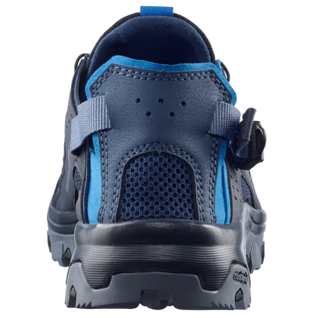 A close-up rear view of a dark blue and bright blue athletic shoe with a hook-and-loop strap closure, set against a light gray background.