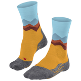 A pair of crew socks with a mountain landscape pattern, featuring a mustard yellow body, gray toe and heel areas, and light blue and brown mountain peaks on the cuff.