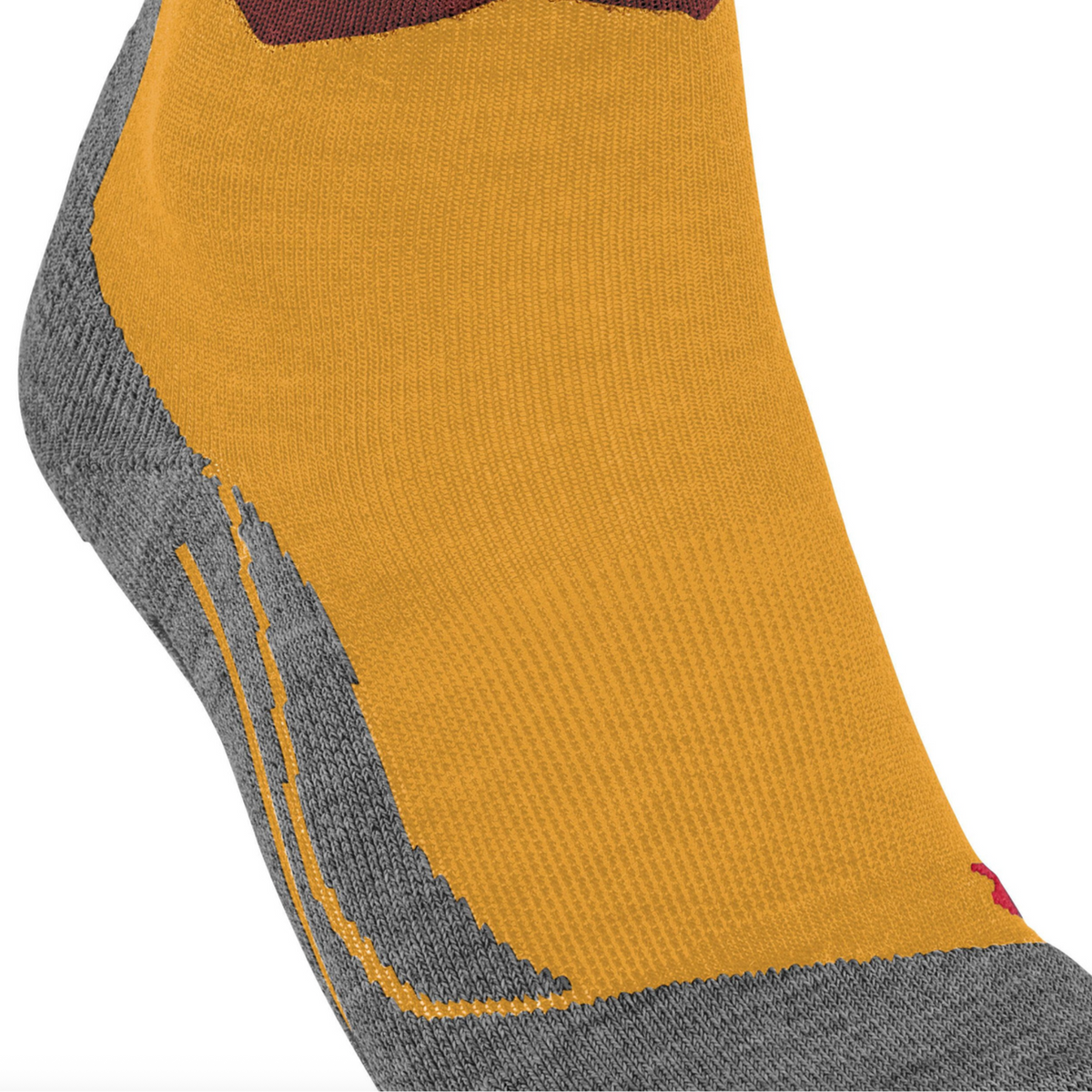 A close-up of a low-cut sock with a mustard yellow main body, gray heel and toe, and a wavy pattern of brown, rust, and light blue near the cuff, shown on a white background.