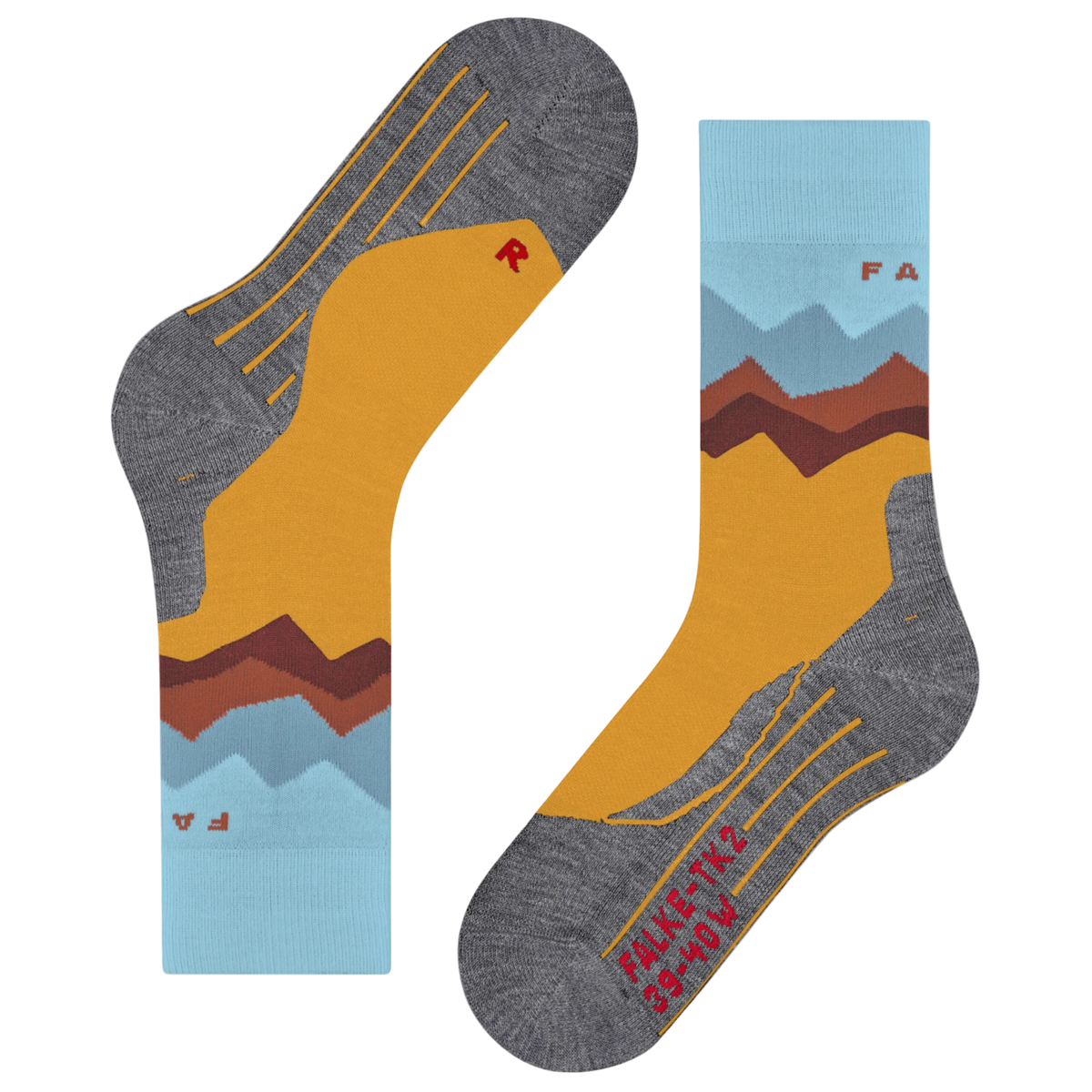 A pair of crew socks shown flat on a white background, featuring a mountain landscape design with a mustard yellow field, brown and red peaks, light blue sky layers, and heather gray toe/heel areas with yellow line details.